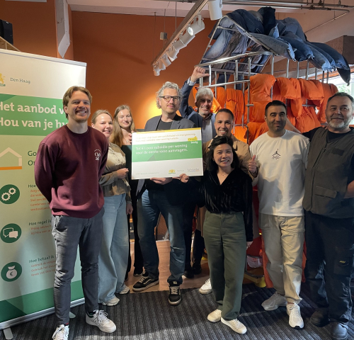 A group of people posing with an information sign in The Hague.