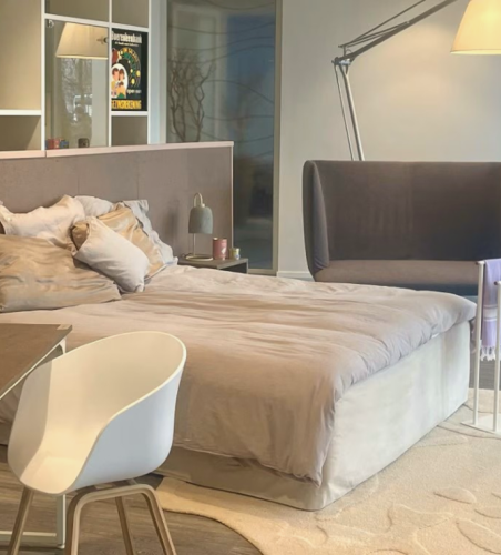 Bedroom hotel room with bed, desk, and plant with products made out of seaweed