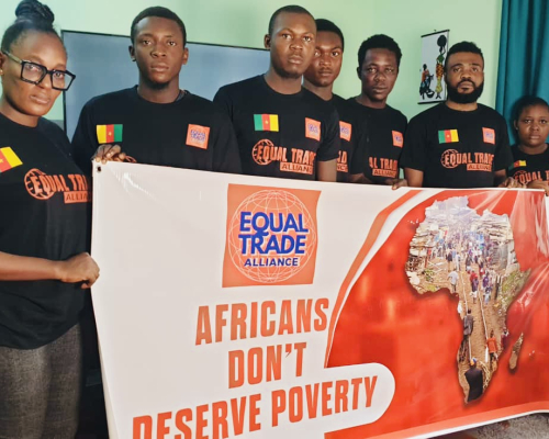 Seven people in black shirts holding a poster reading 'Africans don’t deserve poverty'.