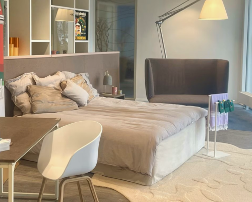 Bedroom hotel room with bed, desk, and plant with products made out of seaweed