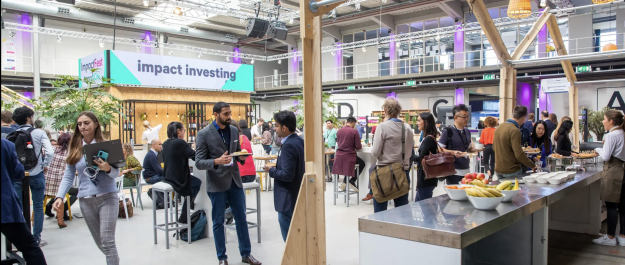 Picture taken at ImpactFest 2022 with a large sign in the background stating 'Impact Investing'.