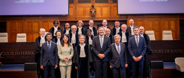 Group of people in robes posing in the courtroom.