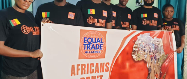 Seven people in black shirts holding a poster reading 'Africans don’t deserve poverty'.