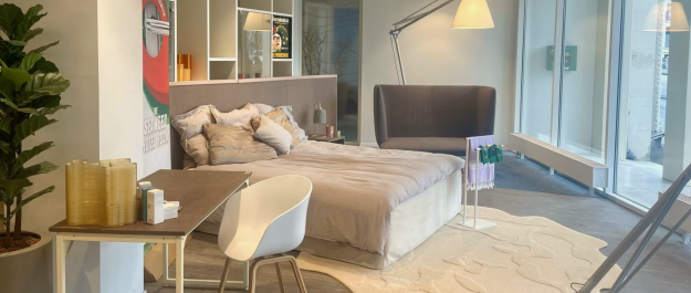 Bedroom hotel room with bed, desk, and plant with products made out of seaweed