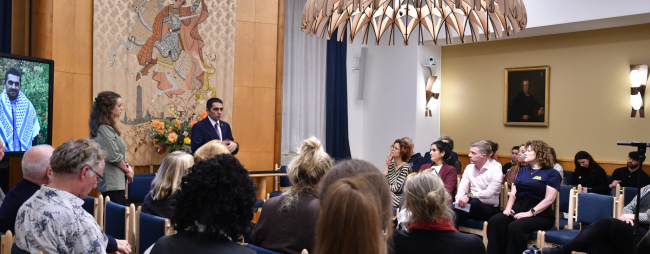 People listen to a speaker in a room with artwork.