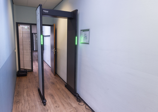 Security screening checkpoint with a walk-through metal detector at the Wijkrechtspraak court location in The Hague Southwest, ensuring safe access to the community courtroom.
