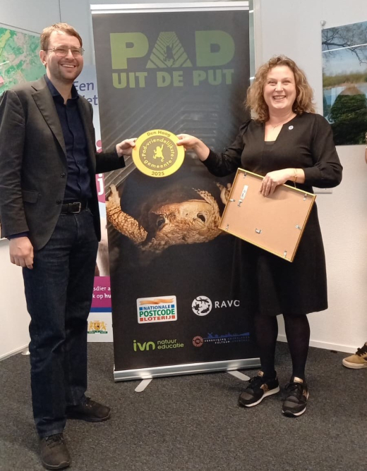 Alderman Robert Barker (left) with Karin Akkers, Director of RAVON standing besides the banner with the award. 