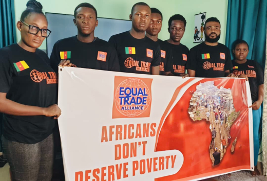 Seven people in black shirts holding a poster reading 'Africans don’t deserve poverty'.
